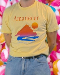 a man wearing a yellow t - shirt standing in front of a bunch of candy canes