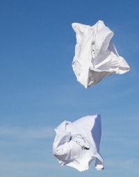 two white paper bags flying in the air