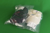 two hats in a plastic bag on a green background