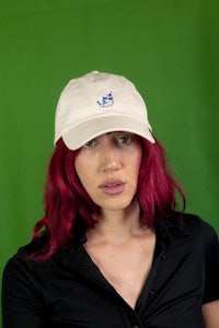 a woman with red hair wearing a hat
