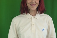 a woman with red hair wearing a polo shirt