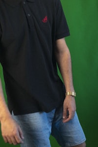 a man wearing a black polo shirt and shorts