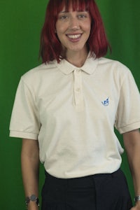 a woman wearing a white polo shirt and black pants