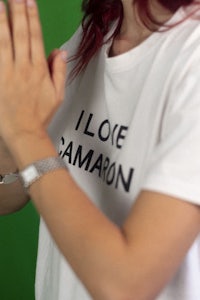 a woman wearing a white t - shirt that says i love camon