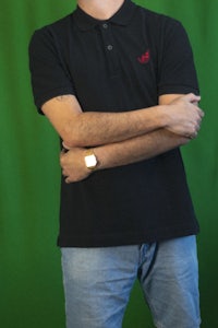 a man wearing a black polo shirt and jeans